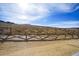 Backyard view showing new construction with a bright blue sky, beautiful mountain views, and a wooden fence at 17054 Hop Clover Ave, Parker, CO 80134