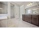 Modern primary bathroom with a glass walk-in shower, double vanity, and granite countertop at 17054 Hop Clover Ave, Parker, CO 80134