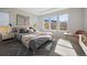 Stylishly staged bedroom with a plush bed, decorative rug, and three sunny windows at 17054 Hop Clover Ave, Parker, CO 80134