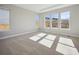 Sunlit bedroom featuring a large window with outside views and neutral carpeted flooring at 17054 Hop Clover Ave, Parker, CO 80134