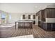 Modern kitchen features a large island, dark cabinetry, stainless steel appliances, and hardwood floors, perfect for cooking at 17054 Hop Clover Ave, Parker, CO 80134