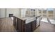 Bright kitchen features a large center island with granite countertop and farmhouse sink at 17054 Hop Clover Ave, Parker, CO 80134