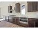 Stylish kitchen featuring dark wood cabinets, granite countertops, and stainless steel appliances, ideal for cooking at 17054 Hop Clover Ave, Parker, CO 80134