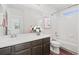 Bright bathroom features a vanity with dark wood cabinets and a shower-tub combination at 1315 Laurel St, Broomfield, CO 80020