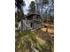 Cabin-style home with a balcony and an attached weathered shed with overgrown vegetation at 27447 Upper Cold Spg Gulch Rd, Golden, CO 80401