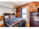 Cozy bedroom features exposed brick wall, decorative pillows, and comfortable bedding at 4337 Umatilla St, Denver, CO 80211