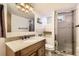 Clean bathroom featuring a granite vanity, a walk-in shower, and neutral tile at 7130 Berthoud St, Westminster, CO 80030