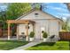A backyard featuring a pergola, a dining table, potted plants, a walkway and grassy lawn at 1474 S Emerson St, Denver, CO 80210