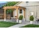 Backyard patio featuring a wooden pergola, outdoor dining, manicured plants, and well-kept lawn at 1474 S Emerson St, Denver, CO 80210