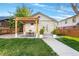 Backyard patio featuring a wooden pergola, outdoor dining set, and manicured lawn at 1474 S Emerson St, Denver, CO 80210