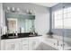 Bright bathroom featuring a double sink vanity, soaking tub, and glass shower at 10384 E 60Th Pl, Denver, CO 80238