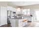 Bright kitchen with white cabinets, stainless steel appliances, granite countertops, and eat-in island at 10384 E 60Th Pl, Denver, CO 80238
