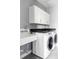 Bright laundry room with modern washer, dryer, sink and upper cabinets at 10384 E 60Th Pl, Denver, CO 80238
