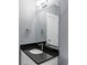 Stylish powder room with a granite countertop and modern mirror at 10384 E 60Th Pl, Denver, CO 80238