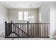 Well-lit staircase landing with dark wood railing and a modern chandelier at 10384 E 60Th Pl, Denver, CO 80238
