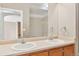 Bright bathroom featuring a double sink vanity with neutral countertops and warm wood cabinetry at 9079 E Panorama Cir # 520, Englewood, CO 80112