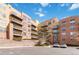 Exterior building view showcasing balconies, brick accents, parking, and landscaping against a partly cloudy blue sky at 9079 E Panorama Cir # 520, Englewood, CO 80112