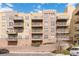 Exterior building view shows balconies, parking, and colorful architecture against a partly cloudy blue sky at 9079 E Panorama Cir # 520, Englewood, CO 80112
