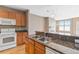 Beautiful kitchen featuring stainless steel sink and granite breakfast bar with bright living room at 9079 E Panorama Cir # 520, Englewood, CO 80112