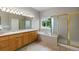 Bright bathroom featuring double sinks, tub, and glass-enclosed shower with a window that brings in natural light at 8007 Sunrise Cir, Frederick, CO 80516