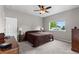 Neutral bedroom with a comfortable bed, dresser, and a large window for natural light at 8007 Sunrise Cir, Frederick, CO 80516