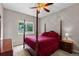 Comfortable bedroom featuring a four-poster bed, a window with backyard views, and a side table with lamp at 8007 Sunrise Cir, Frederick, CO 80516
