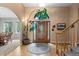 Elegant foyer featuring a wooden front door, hardwood floors, staircase, and arched doorway at 8007 Sunrise Cir, Frederick, CO 80516