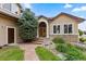 Charming home featuring a stone archway, brick steps, and a wooden door with green landscaping at 8007 Sunrise Cir, Frederick, CO 80516