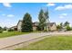 Inviting home featuring a well-manicured lawn, mature trees, and a spacious driveway leading to the attached garage at 8007 Sunrise Cir, Frederick, CO 80516