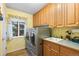 Convenient laundry room featuring modern appliances, a utility sink, ample cabinet space, and a bright window at 8007 Sunrise Cir, Frederick, CO 80516