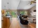 Bright open floor plan with kitchen island and living area featuring a vaulted ceiling and ample natural light at 8007 Sunrise Cir, Frederick, CO 80516