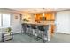 Basement bar area with seating for four, granite countertops, and light wood cabinets at 10773 Cougar Rdg, Lone Tree, CO 80124