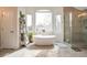 Bright bathroom featuring a large soaking tub, walk-in shower, and large windows at 10773 Cougar Rdg, Lone Tree, CO 80124