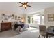 Bright bedroom with a bay window, ceiling fan, and eclectic gallery wall; a cozy and inviting space at 10773 Cougar Rdg, Lone Tree, CO 80124