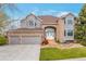 Beautiful two-story home with brick and stucco, arched entryway, three-car garage, and professionally landscaped front yard at 10773 Cougar Rdg, Lone Tree, CO 80124