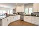 Modern kitchen with sleek white cabinets, stainless steel appliances, granite countertops, and wood flooring at 10773 Cougar Rdg, Lone Tree, CO 80124