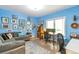 Bright blue living room with hardwood floors, couch, many pictures and a window for natural light at 10773 Cougar Rdg, Lone Tree, CO 80124