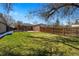 Expansive backyard showcasing green grass, a patio area, and privacy fencing at 1632 Ulster St, Denver, CO 80220