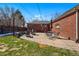 Backyard brick patio has a dining set, seating around a fire pit, and a brick house backdrop at 1632 Ulster St, Denver, CO 80220