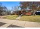 Quaint single story house with brick facade, lawn and walkway leading to the front door at 1632 Ulster St, Denver, CO 80220