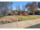 Attractive brick home with lush lawn, rock wall, and sidewalk appeal at 1632 Ulster St, Denver, CO 80220