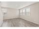 Bright living room with gray wood floors and ample natural light from large windows at 17817 Dandy Brush Dr, Parker, CO 80134