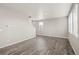 Open-concept living room featuring gray wood floors, neutral walls, and ample light at 17817 Dandy Brush Dr, Parker, CO 80134