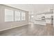 Open-concept living room with gray wood flooring and white kitchen with modern appliances at 17817 Dandy Brush Dr, Parker, CO 80134