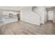 Open living space with white kitchen, island seating, and stairway at 17817 Dandy Brush Dr, Parker, CO 80134
