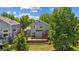 Aerial view of the home's exterior featuring a wood deck and mature trees at 10570 Echo Ct, Firestone, CO 80504
