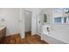 Bright bathroom offers wood floors, combo tub and shower, and updated fixtures at 10570 Echo Ct, Firestone, CO 80504