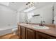 This bathroom includes a double vanity with a large mirror and a shower-tub combination at 10570 Echo Ct, Firestone, CO 80504