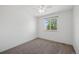 Neutral carpeted bedroom features a ceiling fan and large window at 10570 Echo Ct, Firestone, CO 80504