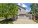 Charming two-story home with a three-car garage and mature landscaping on a sunny day at 10570 Echo Ct, Firestone, CO 80504